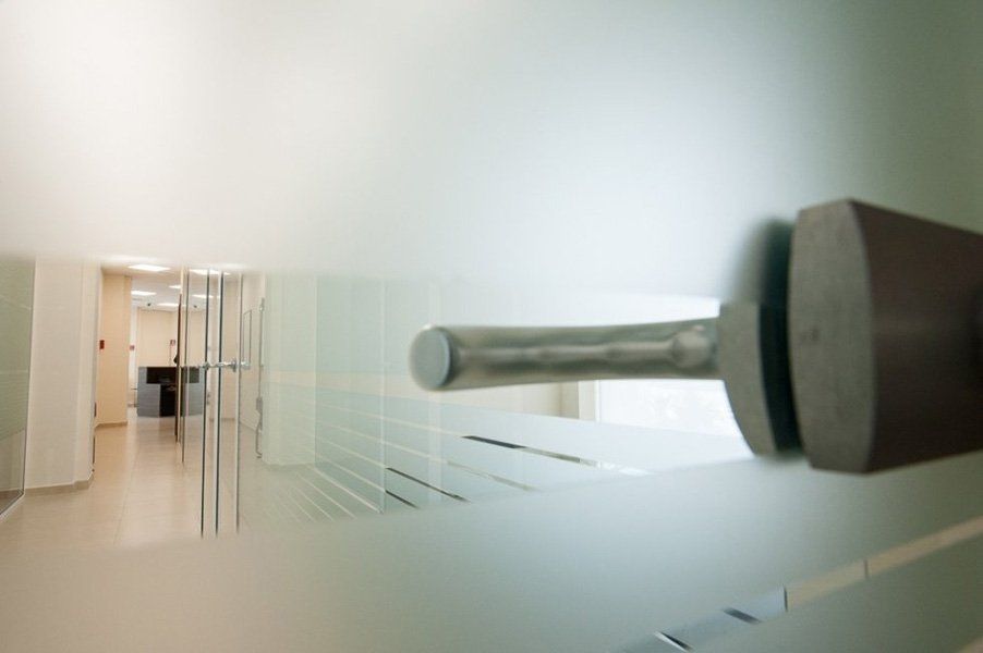Una porta in vetro con maniglia in acciaio inox