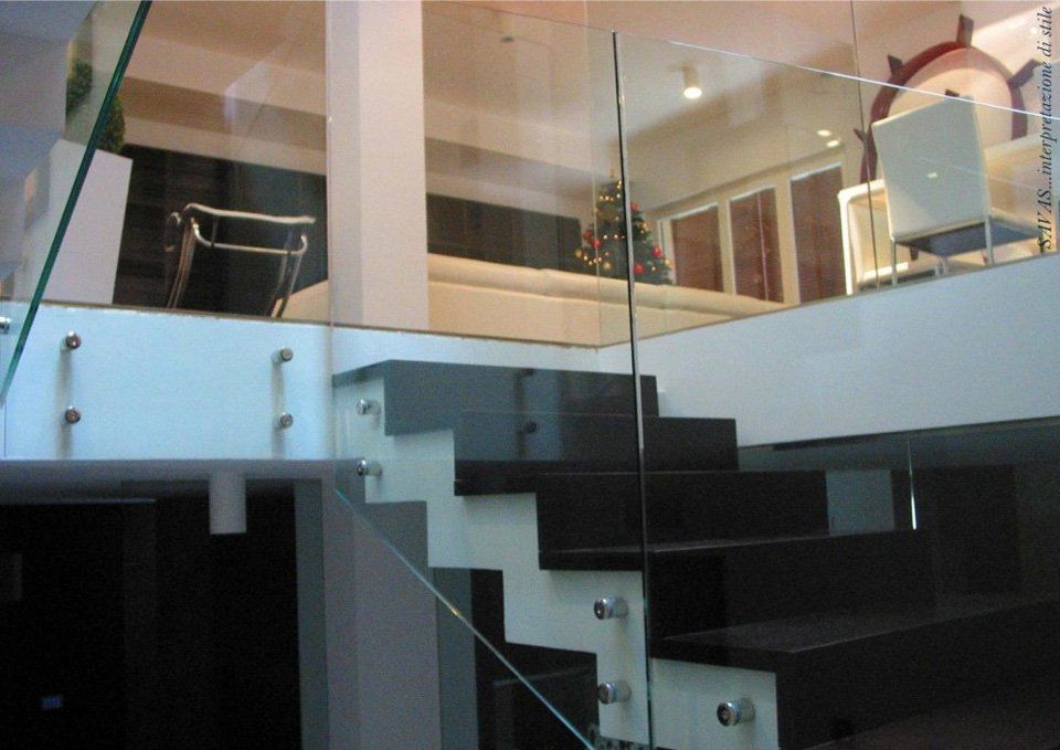 Una scala in bianco e nero con ringhiera in vetro