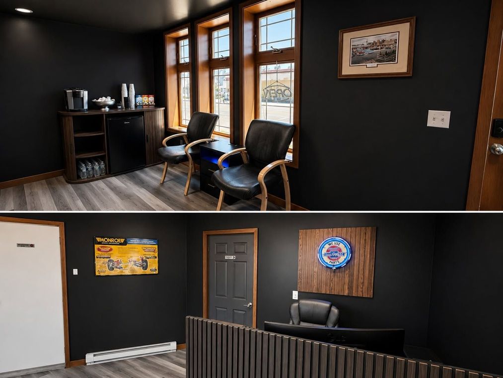 Small office interior with dark walls, windows, desk, chairs, and framed wall art