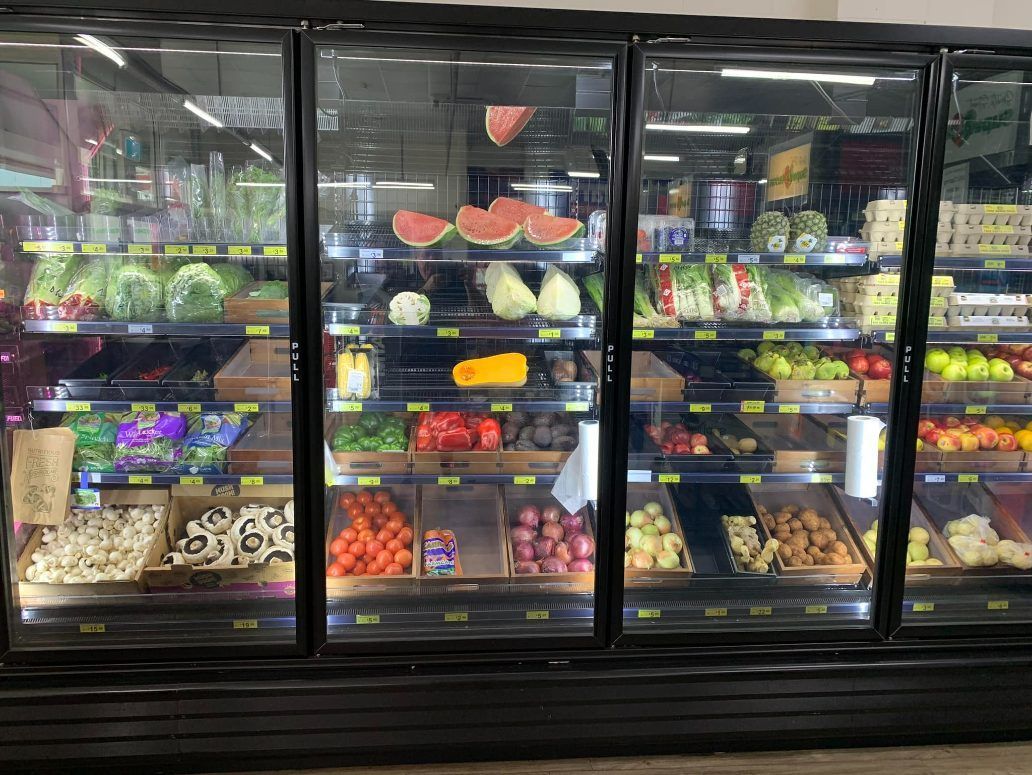 A grocery store refrigerator filled with fruits and vegetables. — Smith Street Supermarket In Darwin City, NT