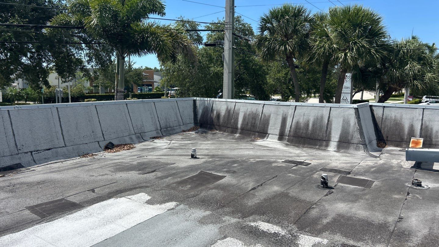 old flat roof on commercial building showing damage