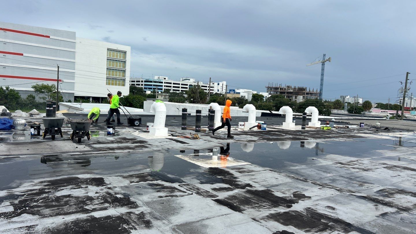 Nast Roofing professionals working on a flat roof in South Florida suffering from ponding water