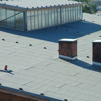 There are two chimneys on the roof of a building.