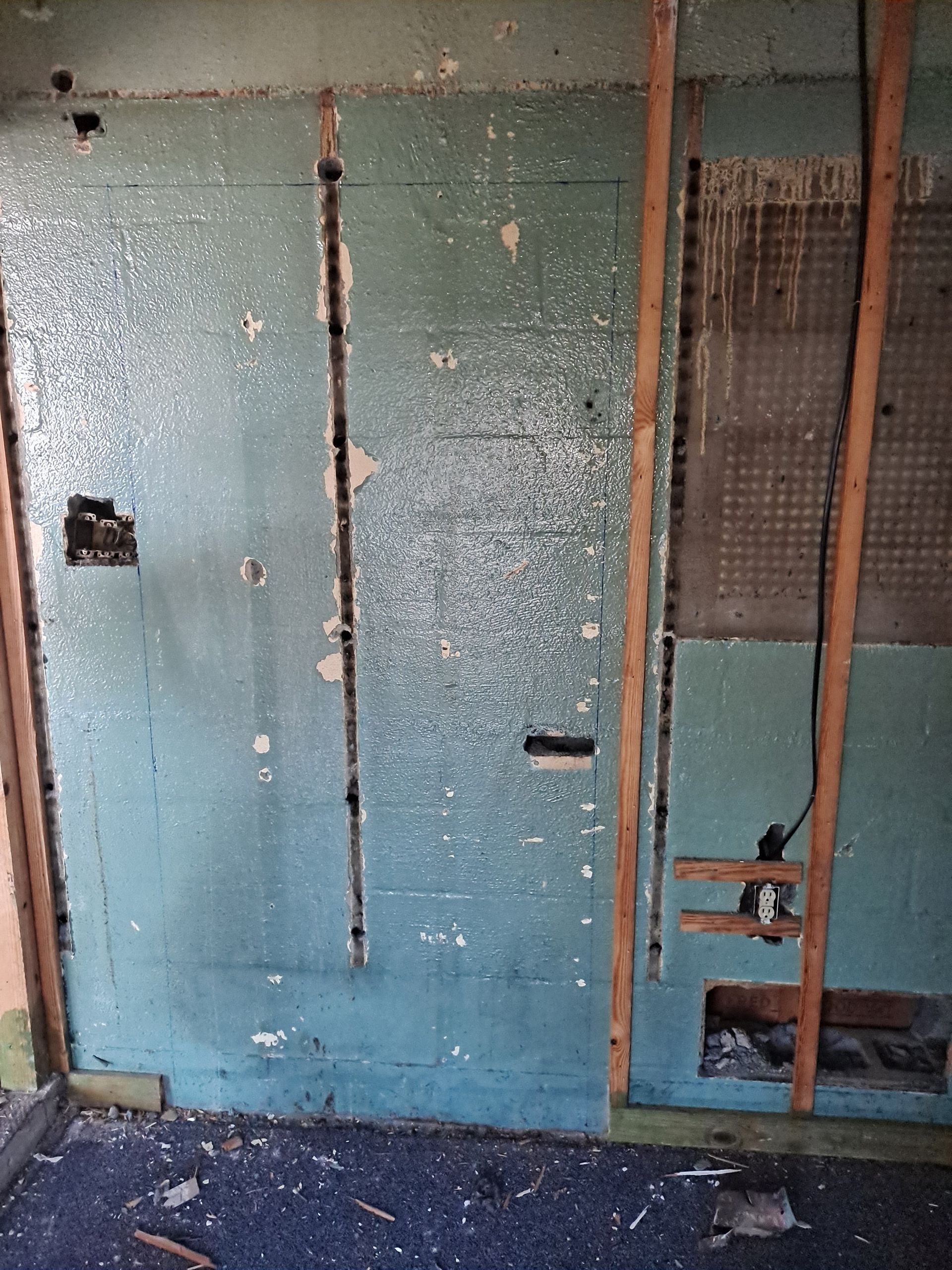 A room with a blue wall and wooden beams.