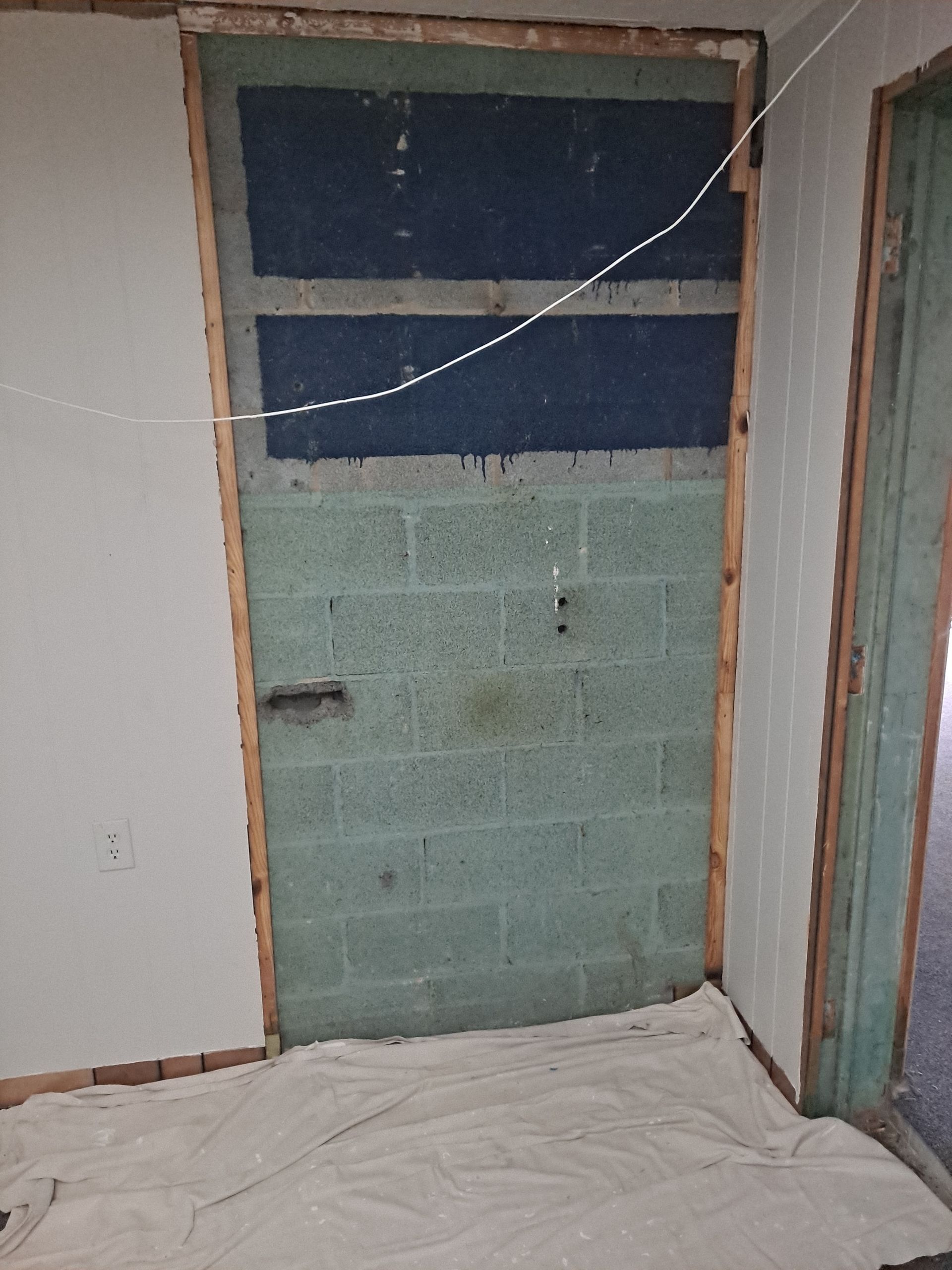 A room with a brick wall and a door.