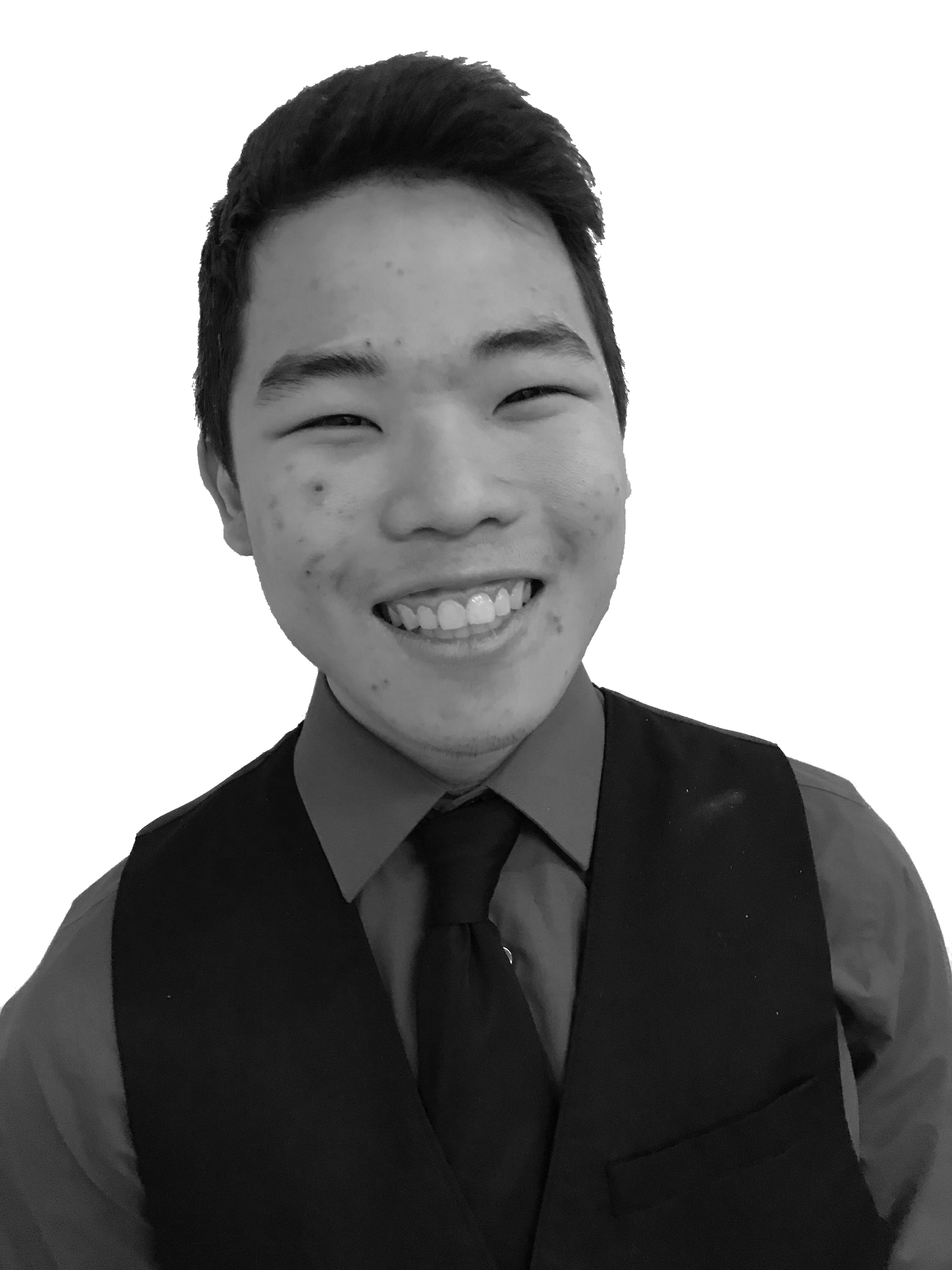 Smiling person in a dark vest, shirt, and tie against a plain background