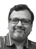 Smiling man with glasses and salt-and-pepper goatee in a striped shirt