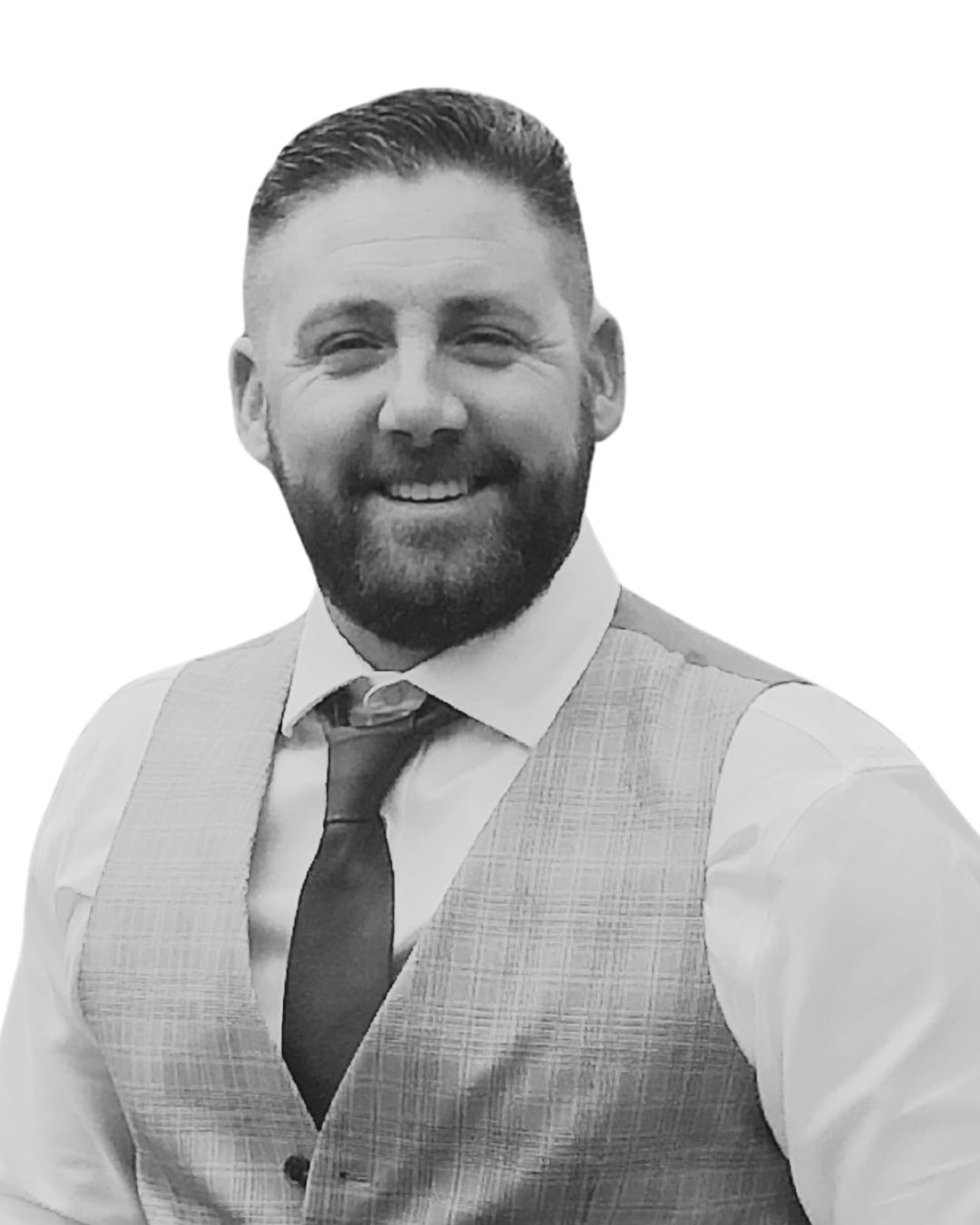 Man with a beard smiling, wearing a vest, shirt, and tie; studio portrait.