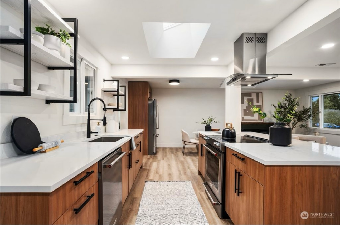 Modern kitchen with wood cabinets, white countertops, and stainless steel appliances.