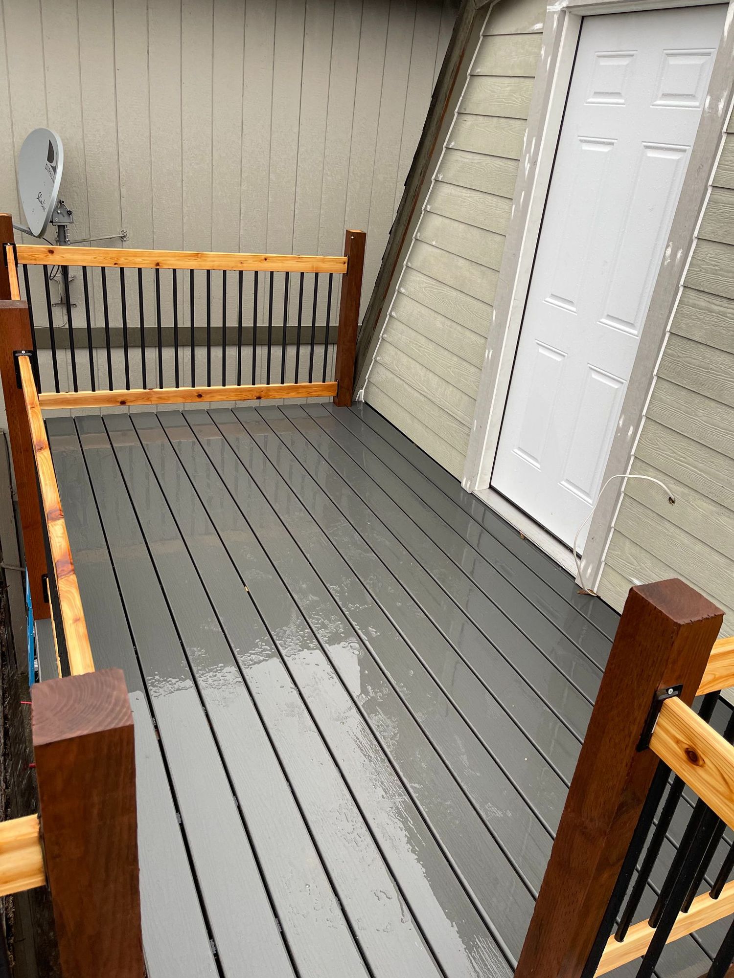 Gray deck with brown railing and door. Satellite dish visible.