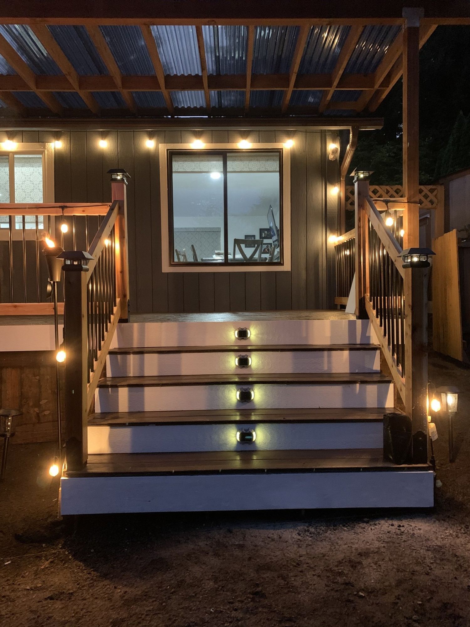 Outdoor stairs leading to a building with string lights; steps are illuminated.