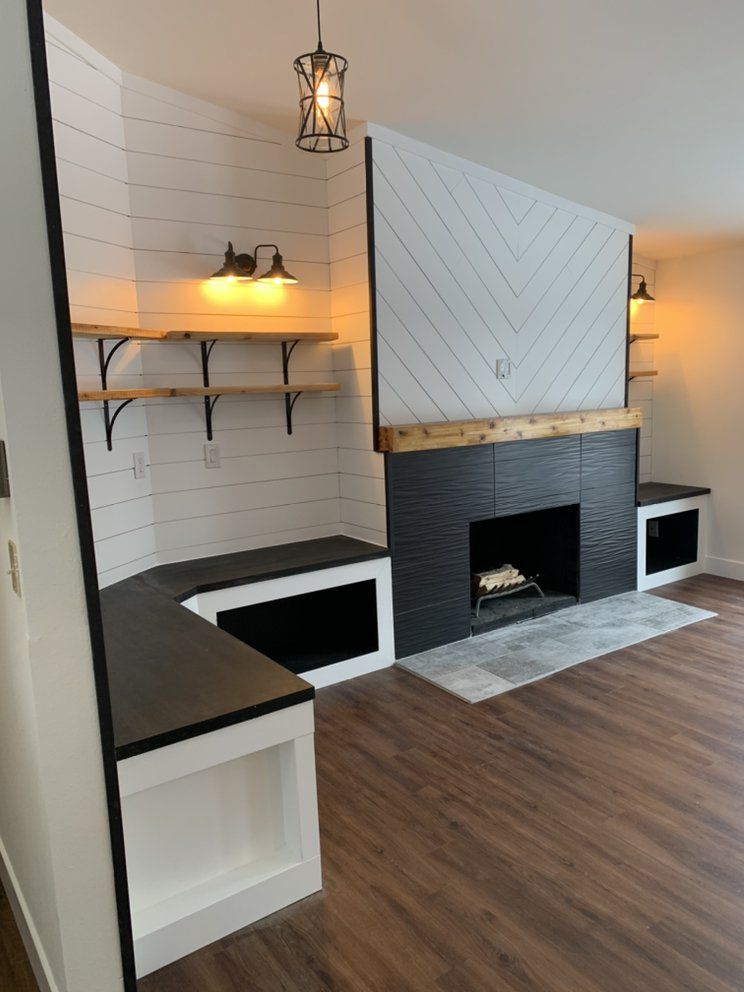 Living room with a black fireplace, white and wood accents, and built-in benches.
