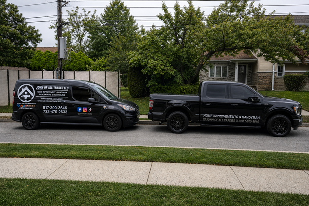 Two black service vans with company logos parked along a suburban street.