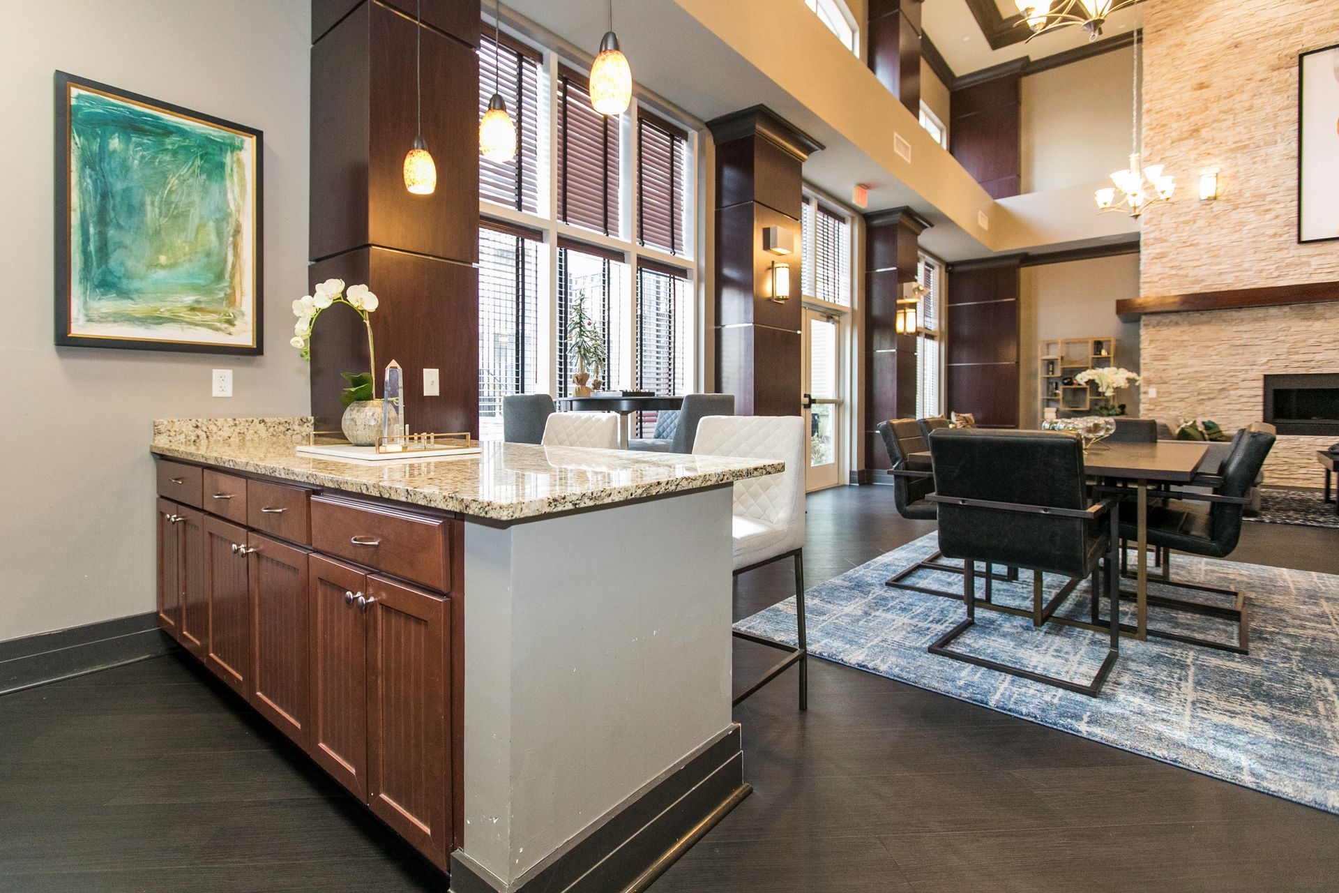 Modern open kitchen and dining area with dark wood cabinets, granite island, and pendant lights at Verde at Howard Square West Apartments in Elkridge, MD.