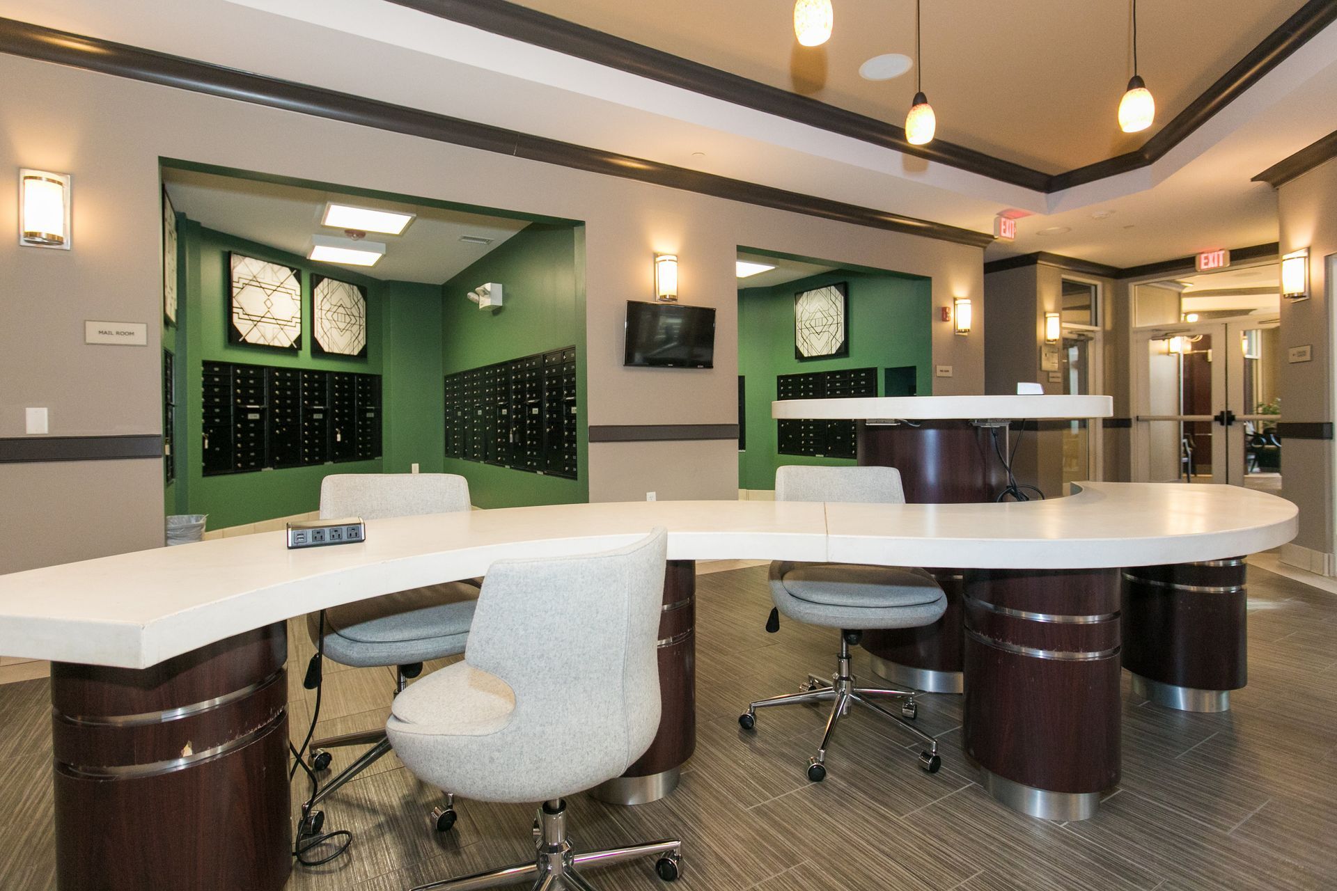 Modern salon interior with white styling stations, mirrors, pendant lights, and black storage cabinets at Verde at Howard Square West Apartments in Elkridge, MD.