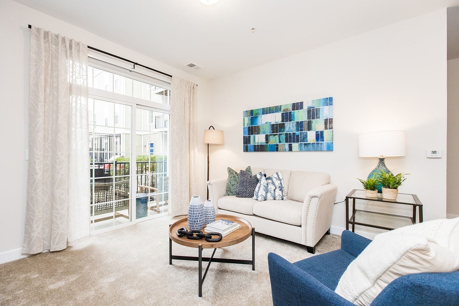 Furnished apartment living room with balcony access and large windows at Verde at Howard Square West Apartments in Elkridge, MD.