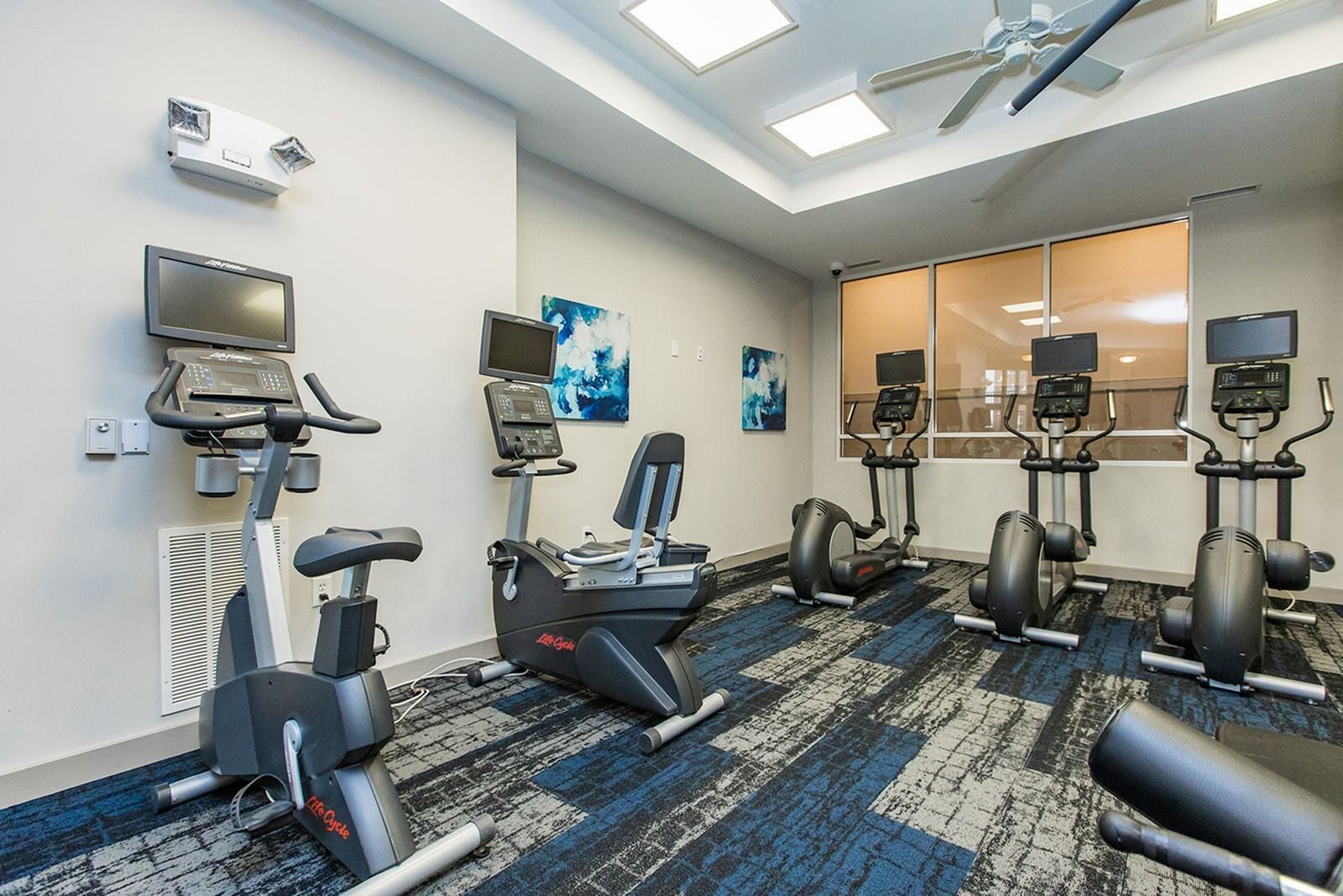 Fitness center with cardio equipment and exercise bikes at Verde at Howard Square West Apartments in Elkridge, MD.