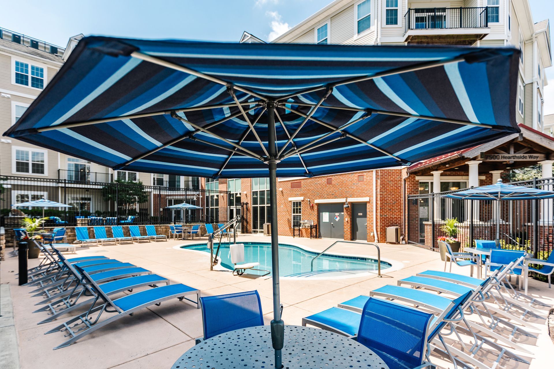 Swimming pool with shaded seating and lounge chairs at Verde at Howard Square West Apartments in Elkridge, MD.