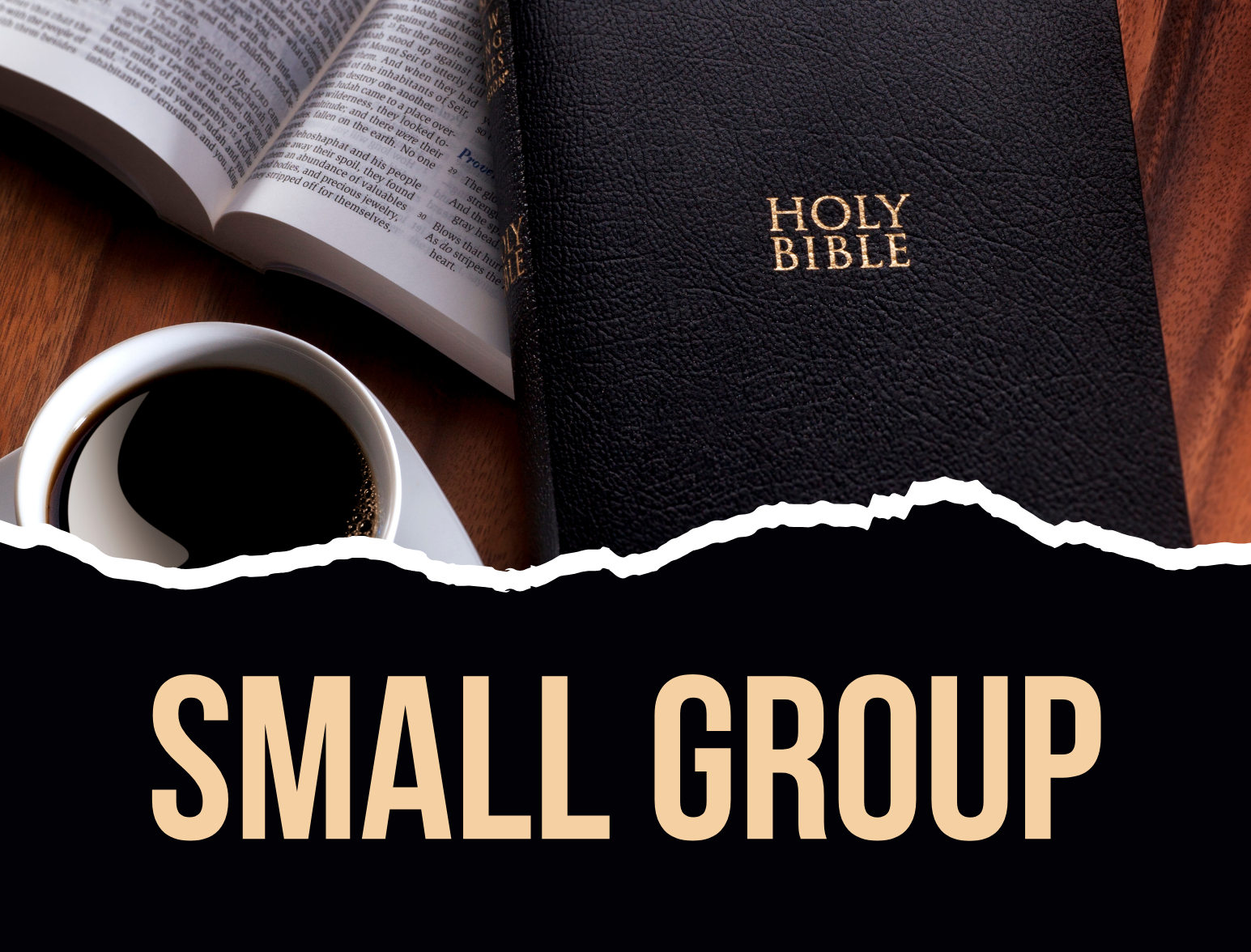 A holy bible sits on a wooden table next to a cup of coffee