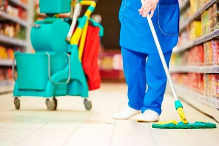 A cleaner is mopping the floor of a supermarket.