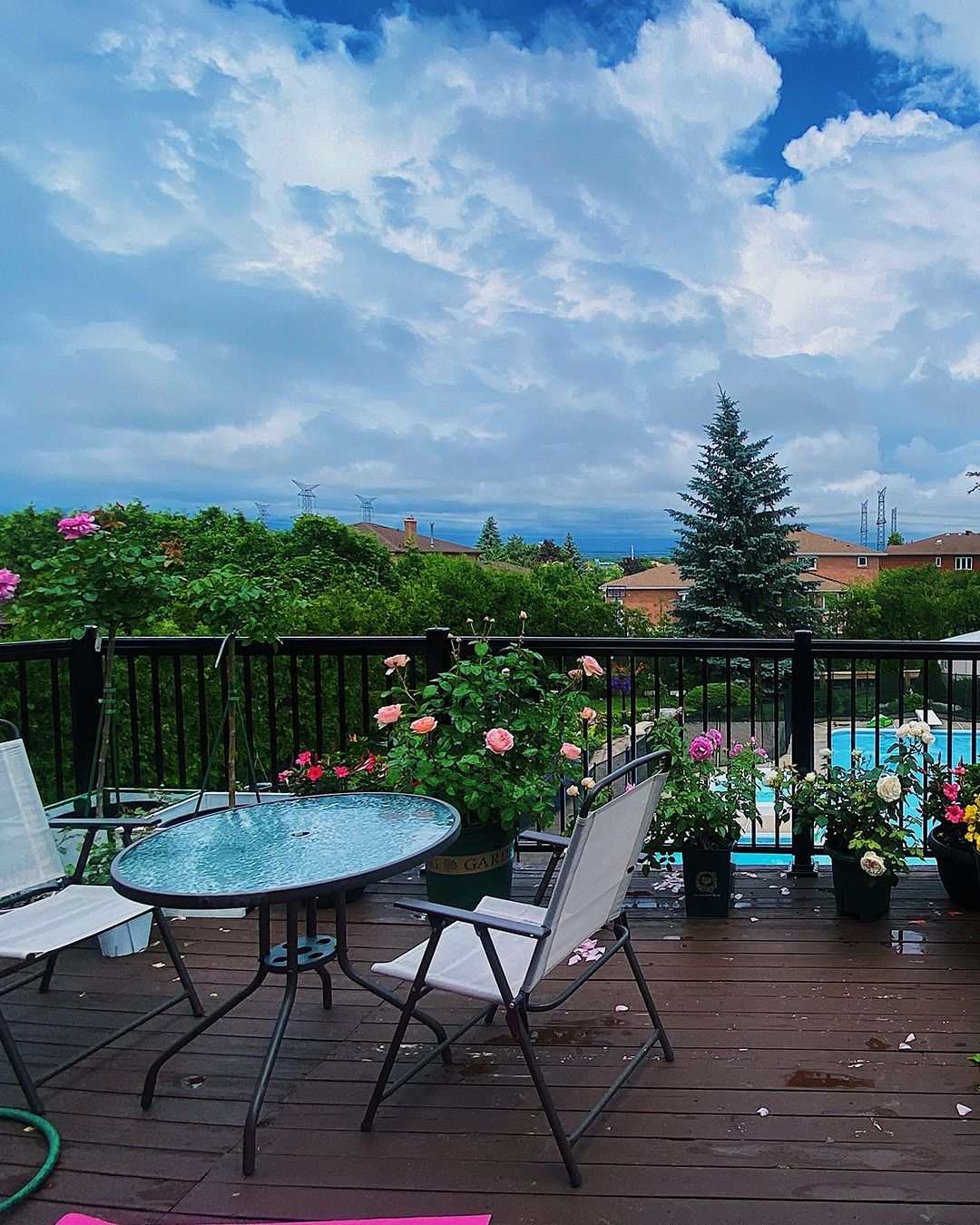A table and chairs on a deck overlooking a pool