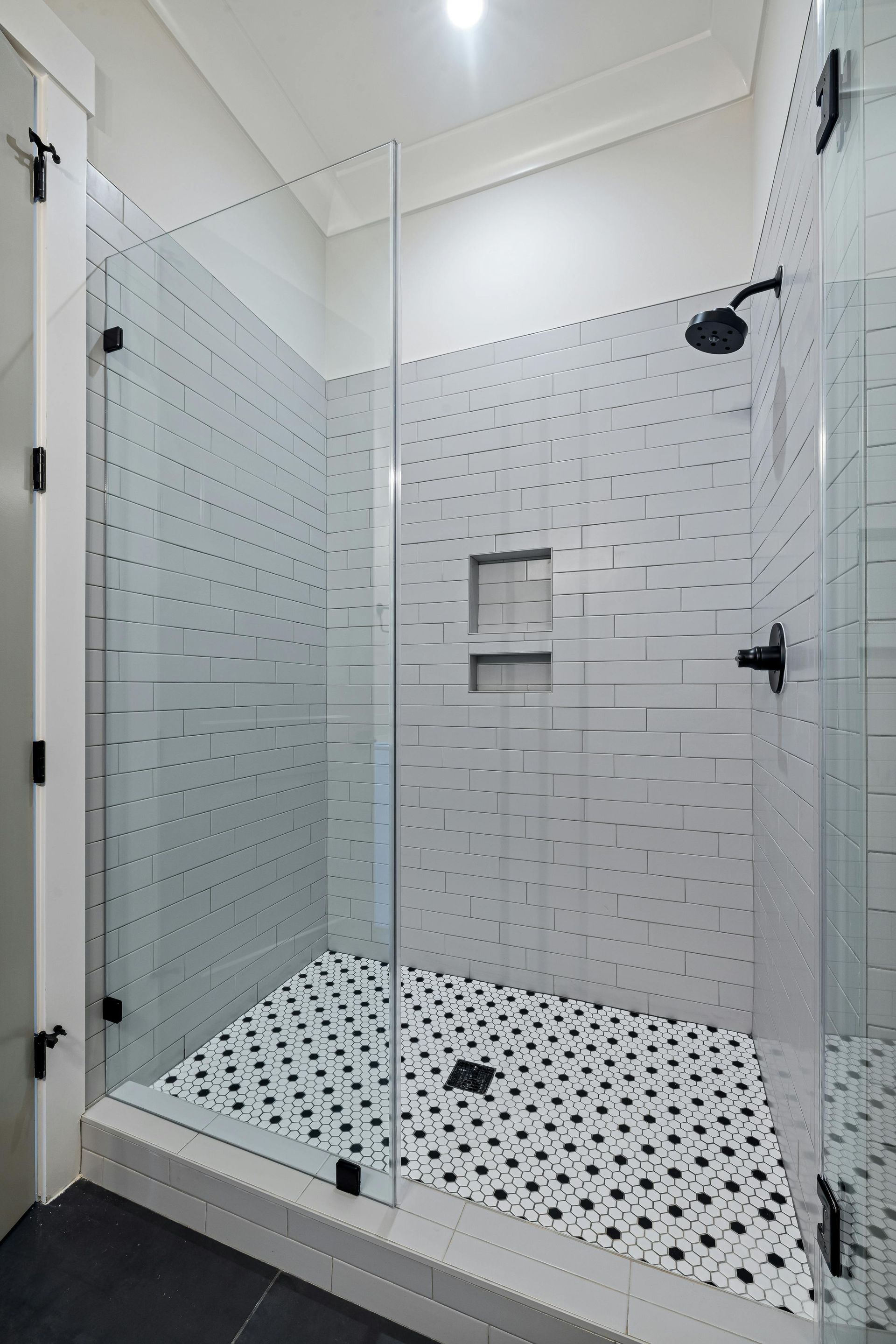 white tile shower with frameless glass door