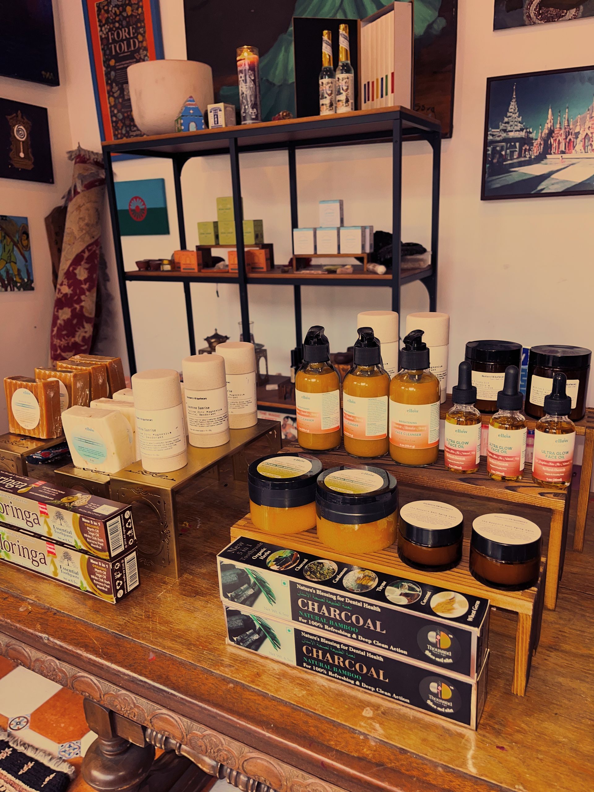 Display of small jars and bottles of candles and soaps on wooden shelves in a cozy shop interior