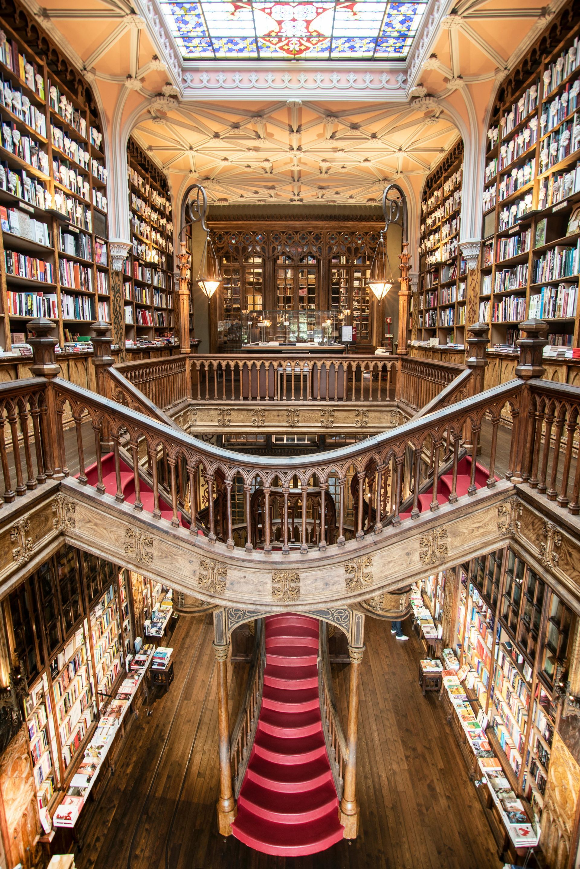 A large library with stairs and a red carpet.