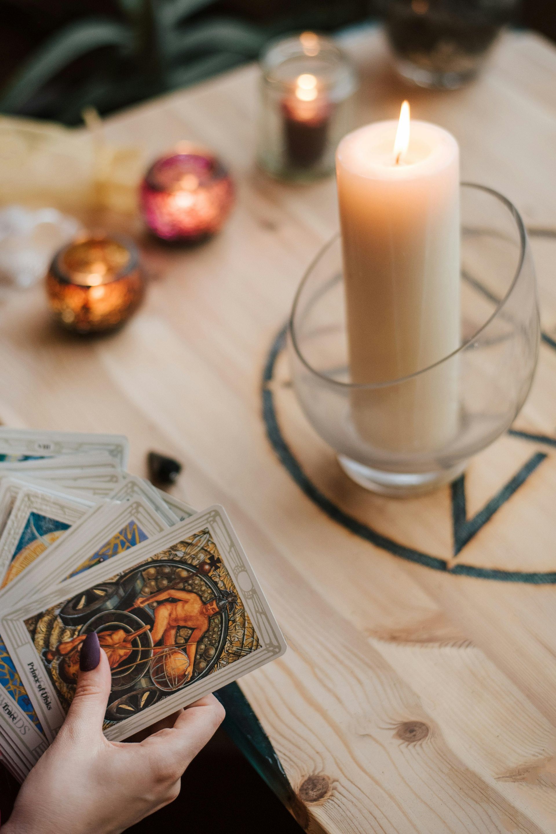 A wooden tray filled with candles and a book on a table.