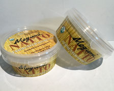Two containers of magnum natio are sitting next to each other on a table.
