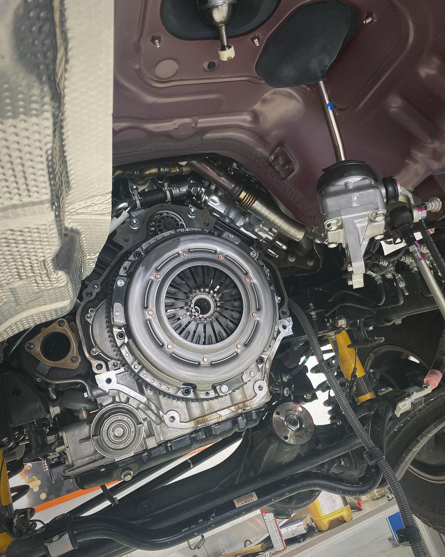 A close up of a car engine with the clutch removed