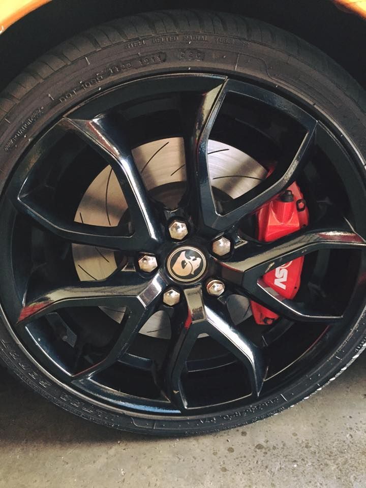 A close up of a car wheel with a red brake