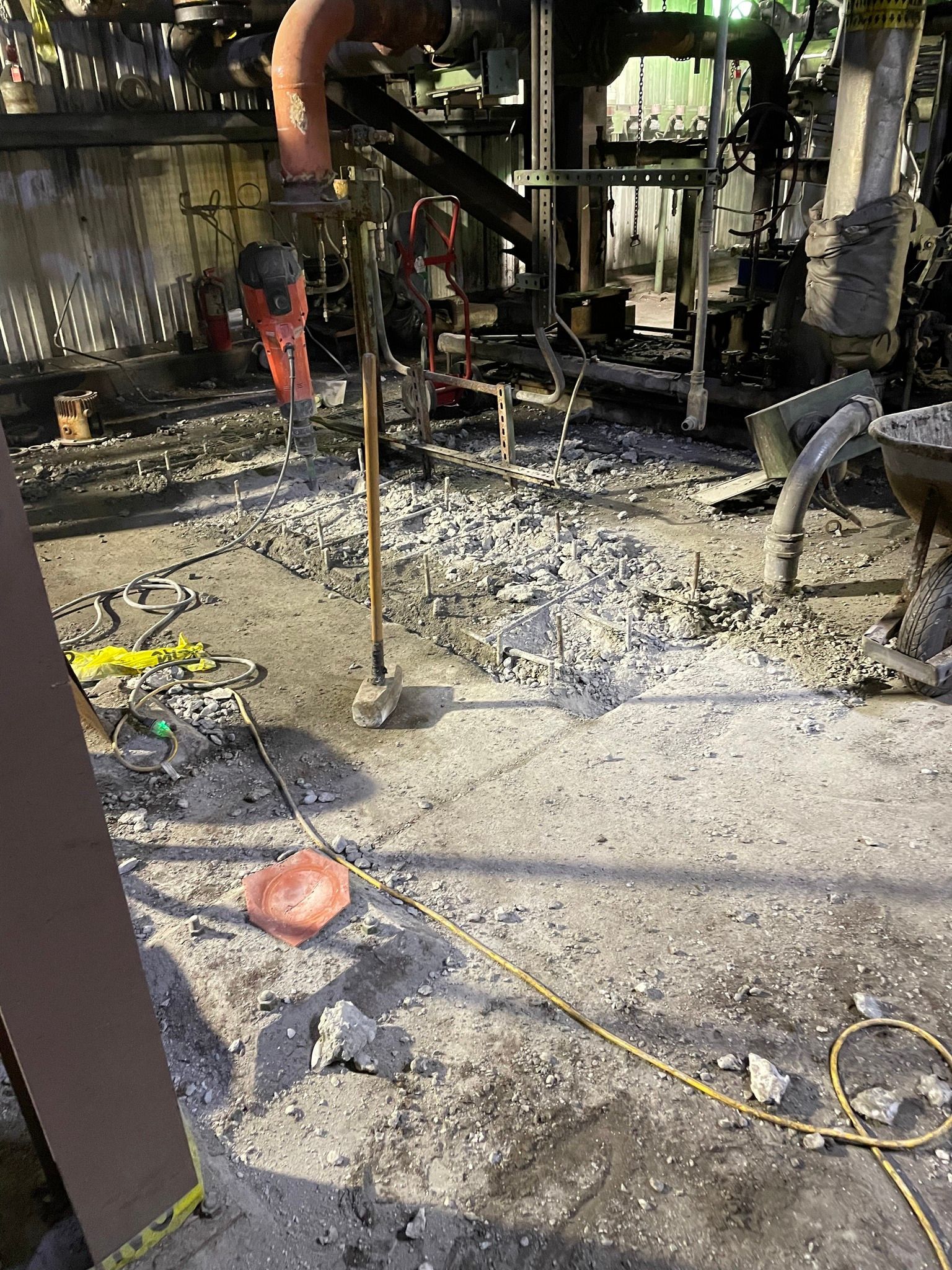 A person is working on a concrete floor in a factory.