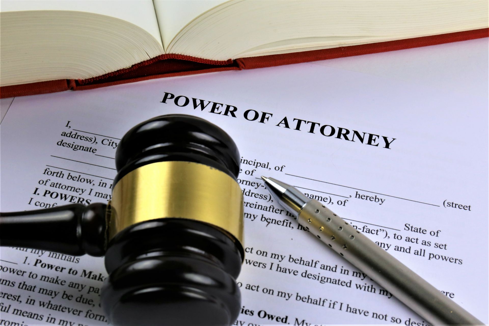 A judge’s gavel and a pen rest on a Power of Attorney legal document. A judge’s gavel and a pen rest on a Power of Attorney legal document.