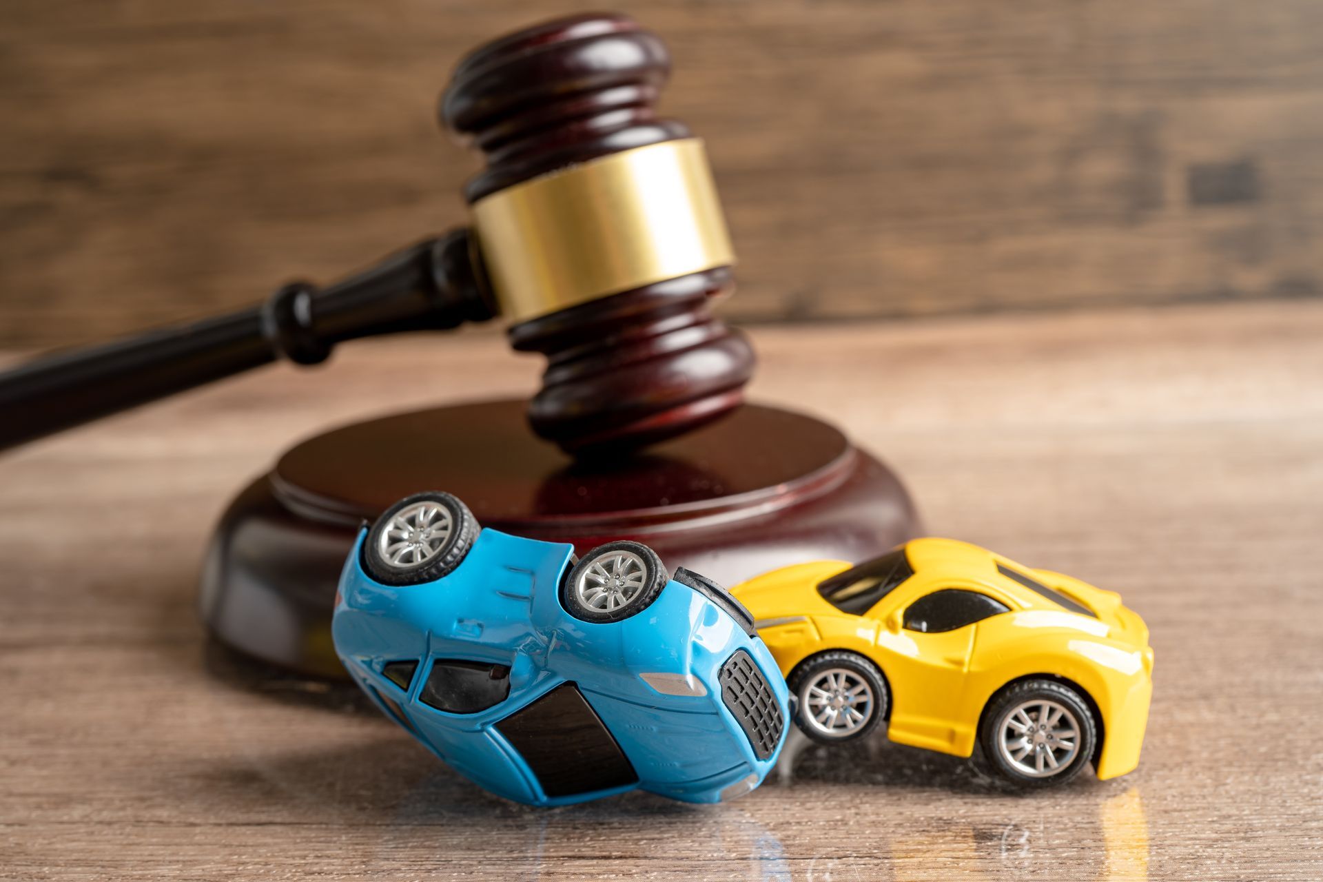 Judge’s gavel beside wrecked car, symbolizing accident case and justice. Judge’s gavel beside wrecked car, symbolizing accident case and justice.