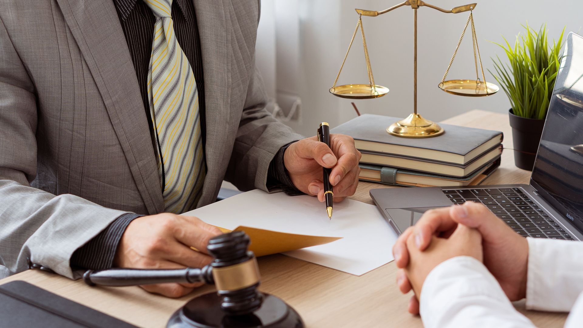 Picture of lawyers discussing documents while sitting at a desk in the office