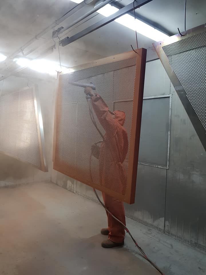 In A Room, A Large Piece Of Wood Is Being Held By A Man — Border Security Doors & Powder Coating in Wodonga, VIC