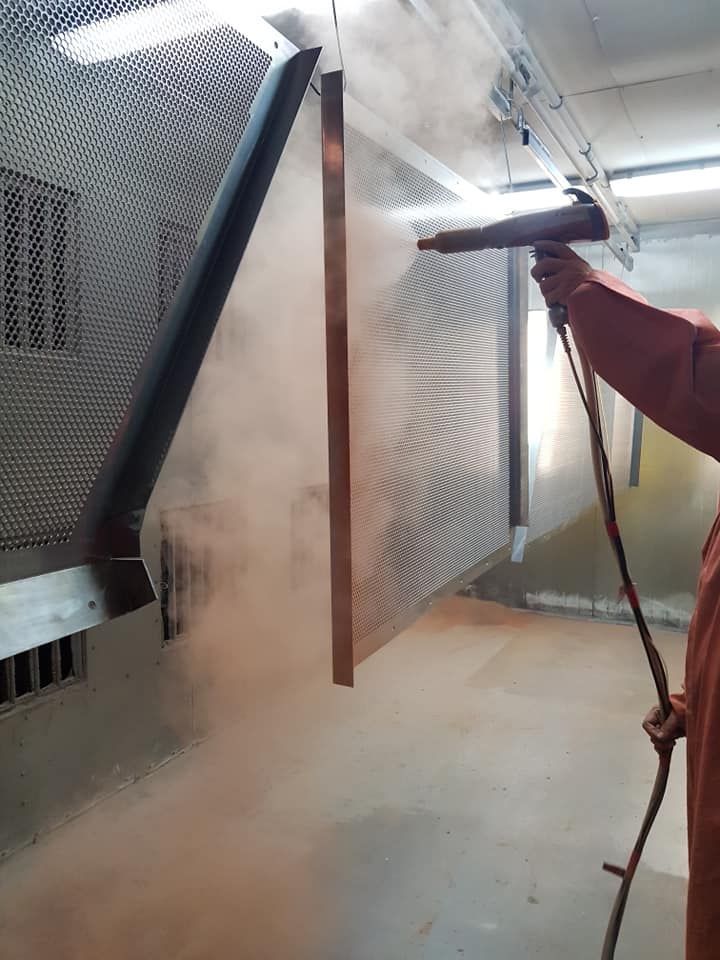 A Man Is Spraying Powder Paint On A Wall In A Room 
