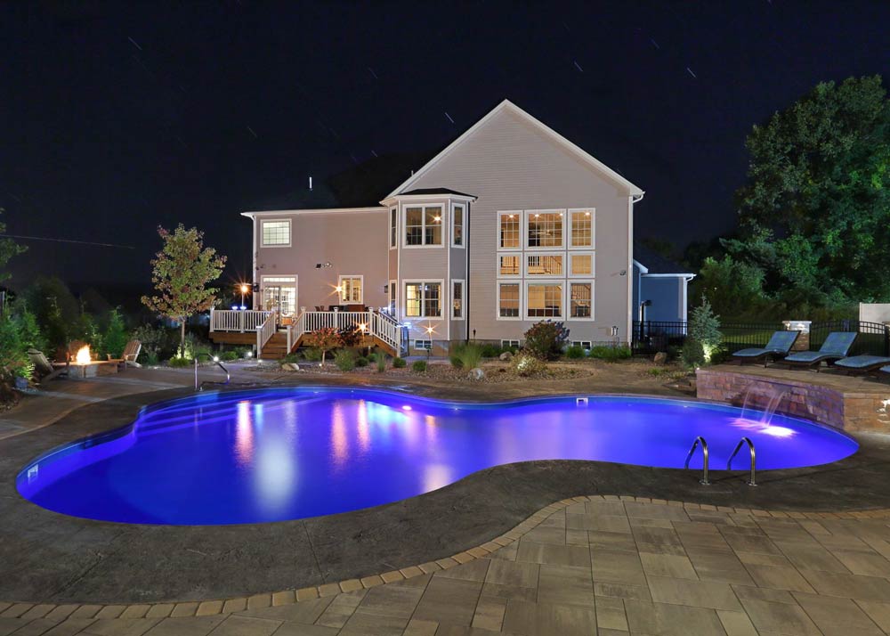 A large house with a large swimming pool in front of it