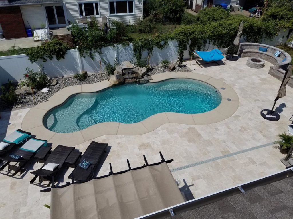 An aerial view of a large swimming pool surrounded by chairs and umbrellas