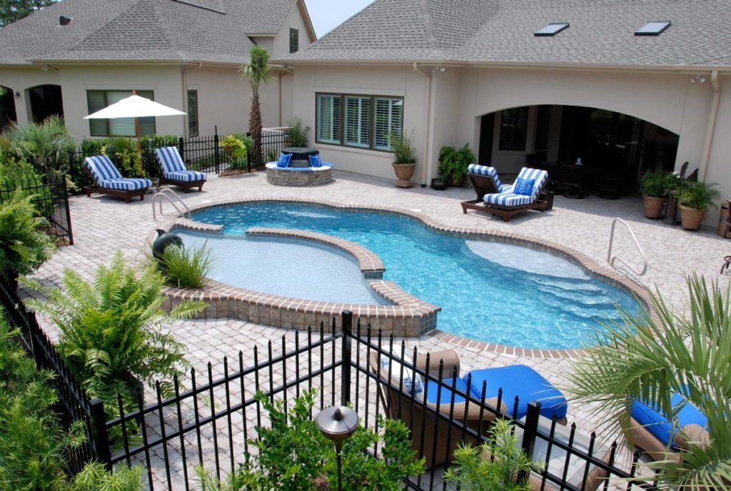 A large swimming pool is surrounded by chairs and umbrellas