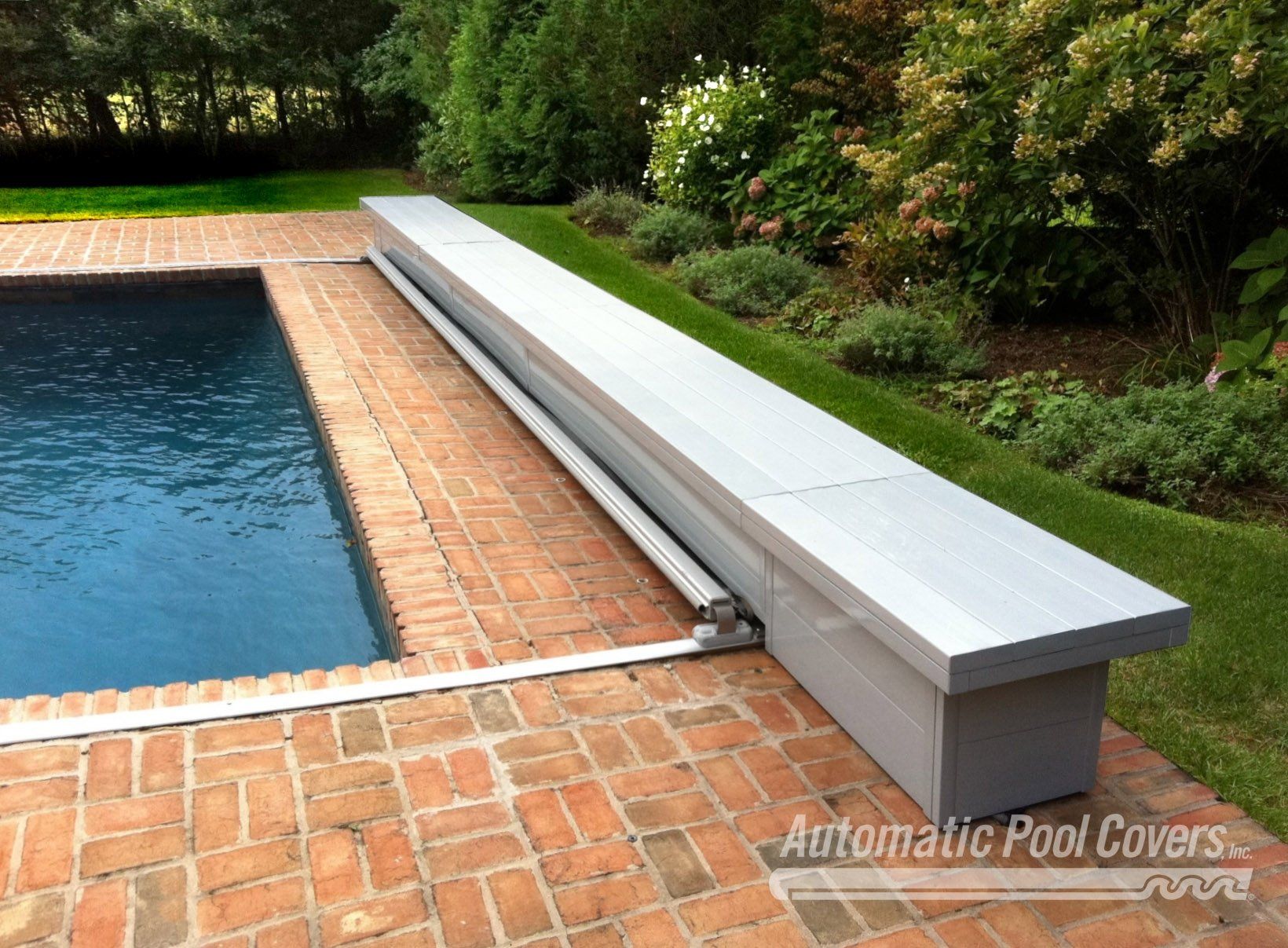 A swimming pool with automatic pool covers on it