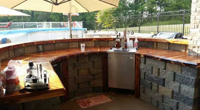 A kitchen with a curved counter top and a stainless steel dishwasher.