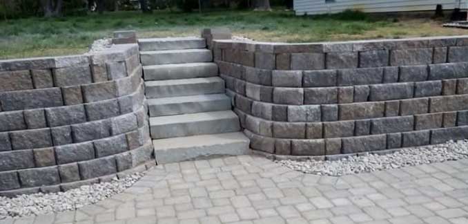 A stone wall with stairs leading up to it.