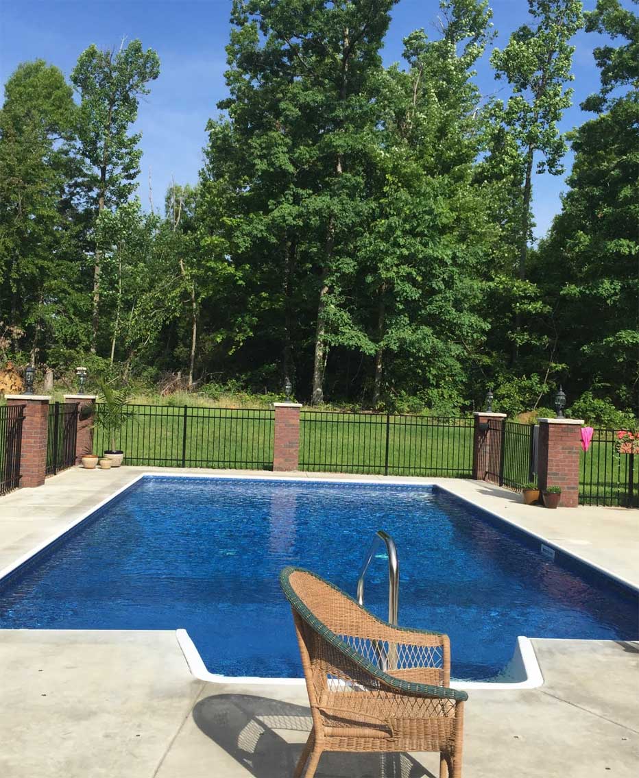 A large swimming pool with a chair in front of it