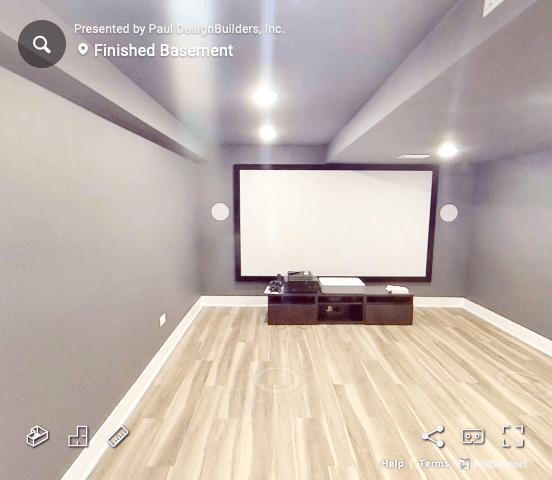 A picture of a finished basement with a projector screen