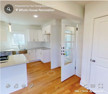A virtual tour of a kitchen with white cabinets and hardwood floors