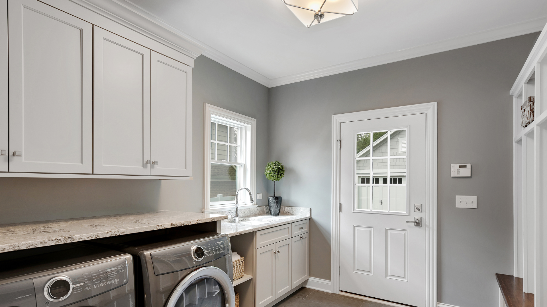 A laundry room with a washer and dryer and a sink.