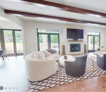 A living room with a couch and chairs and a television