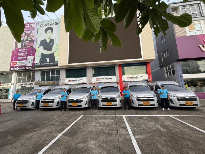 六輛藍白相間的計程車停在一棟有阿拉伯語招牌和一塊大型空白廣告看板的建築物前。